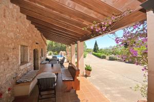 um pátio exterior com uma pérgola de madeira em Villa Alba em Llubí