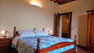 una camera con un grande letto con struttura in legno di Agriturismo Casa Rossa a Chianciano Terme