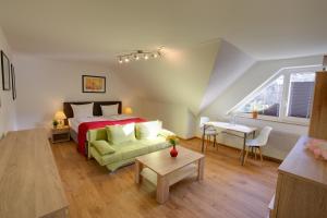 a bedroom with a bed and a couch and a table at Hotel Leo Mühlhausen in Mühlhausen +81 photos