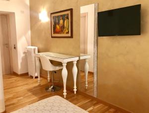 羅馬的住宿－比安卡露娜旅館，墙上有电视的房间里一张桌子