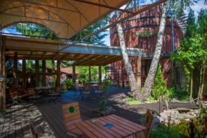 d'une terrasse avec une table, des chaises et un arbre. dans l'établissement Poziomka, à Kujan