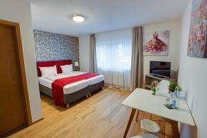 a hotel room with a bed and a television at Hotel Leo Mühlhausen in Mühlhausen