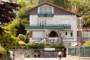 奥利奥Casa Rural Mailan PARKING INCLUIDO的一个人在房子前面骑着自行车