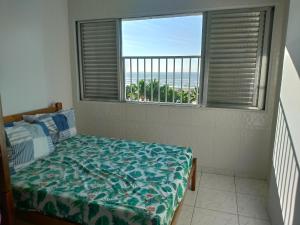 Schlafzimmer mit einem Bett und Meerblick in der Unterkunft Vista para o Mar Praia Grande in Praia Grande