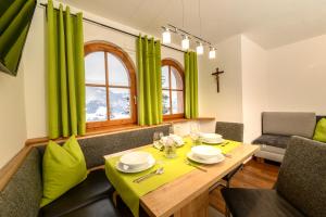 een eetkamer met groene gordijnen en een houten tafel bij Appartement Gruber-Hofer in Altenmarkt im Pongau