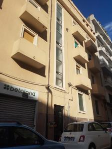 a white car parked in front of a building at Milhouse in Cagliari +7 photos