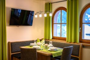 een eetkamer met een tafel met groene gordijnen bij Appartement Gruber-Hofer in Altenmarkt im Pongau