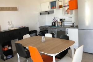 a kitchen with a wooden table and a refrigerator at Location villa 2 chambres A Lavanda piscine Bonifacio in Bonifacio