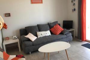 a living room with a gray couch with pillows at Location villa 2 chambres A Lavanda piscine Bonifacio in Bonifacio