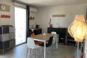 a dining room with a table and chairs and a lamp at Location villa 2 chambres A Lavanda piscine Bonifacio in Bonifacio