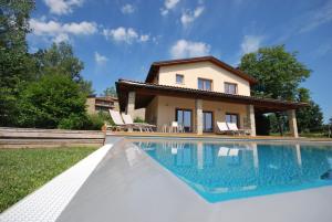 une villa avec une piscine en face d'une maison dans l'établissement Villa Chimera, à Poppi