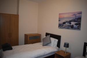 1 dormitorio con 1 cama, vestidor y una foto en Seventy Seven en Gainsborough