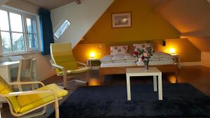 a bedroom with a bed and two yellow chairs at B&B de Oude Hofstee in Maasdam