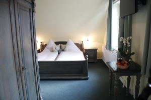 a bedroom with a bed with white sheets and pillows at Landhaus Am Westerwald in Martinfeld