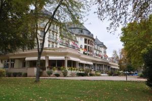 ein großes weißes Gebäude mit Flaggen darauf in der Unterkunft Parkhotel Kurhaus in Bad Kreuznach