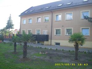 ein Gebäude mit zwei Palmen davor in der Unterkunft Zajazd Pułaskiego in Konstancin-Jeziorna