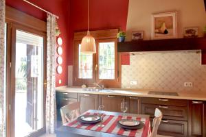 cocina con mesa, sillas y fregadero en Villa Miranda, en El Rompido