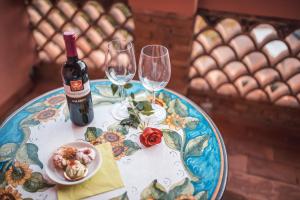 a table with a bottle of wine and two wine glasses at Hotel Villa Sirina in Taormina