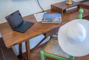 a wooden table with a laptop computer on top of it at Hotel Villa Sirina in Taormina