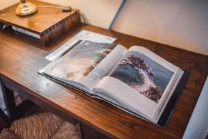 an open book on a wooden table with a lamp at Hotel Villa Sirina in Taormina