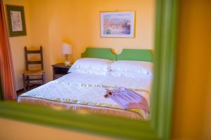 a bedroom with a bed with a green headboard at Hotel Villa Sirina in Taormina