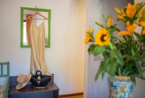 a dressing table with a dress and a vase of flowers at Hotel Villa Sirina in Taormina
