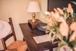 a laptop computer sitting on a wooden table with a lamp at Hotel Villa Sirina in Taormina