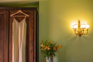 a dress hanging in a room with a vase of flowers at Hotel Villa Sirina in Taormina