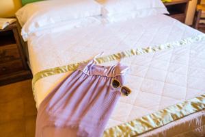 a bed with a dress and sunglasses on it at Hotel Villa Sirina in Taormina