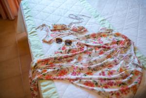 a bed with a blanket and sunglasses on it at Hotel Villa Sirina in Taormina