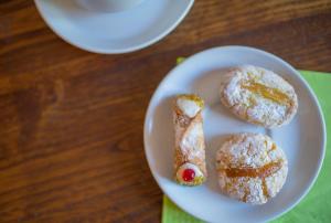 three pastries on a white plate on a table at Hotel Villa Sirina in Taormina