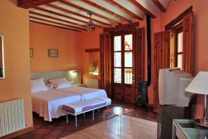 1 dormitorio con 1 cama y TV en una habitación en La Casa Alta &&&, en Belmonte de Tajo