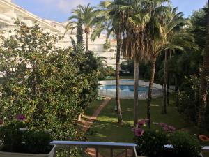 a garden with palm trees and a swimming pool at Quiet place to stay in Marbella