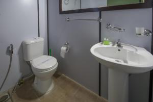 a bathroom with a toilet and a sink at Yala Caravan Village in Kirinda