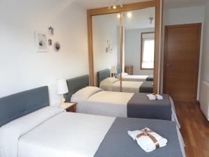 een hotelkamer met 2 bedden en een spiegel bij A&L Playa in Viveiro