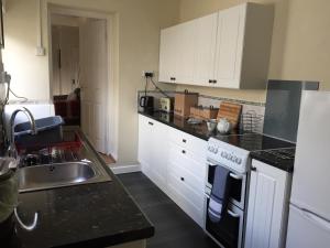 a kitchen with a sink and a stove top oven at 94 High Street in Cross Hands