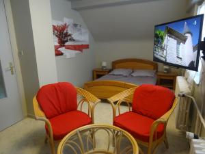 a room with two chairs and a table and a bed at Gîte Henry in Orbey