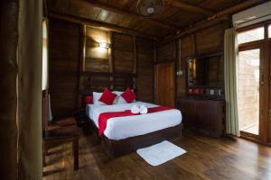 a bedroom with a large bed with red pillows at Yala Caravan Village in Kirinda