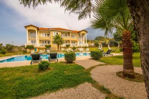 una casa con una piscina y una palmera en Gold Lion Hotel, en Ölüdeniz