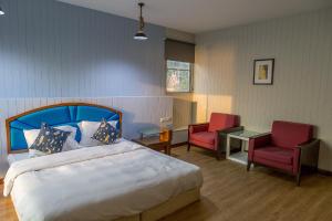 a bedroom with a bed and two red chairs at Chill Days @ Koh Larn in Ko Larn