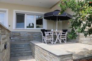 a patio with a table and an umbrella at AZZURO in Kavála