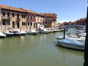un groupe de bateaux amarrés dans un canal avec des bâtiments dans l'établissement House on the water Murano, à Venise