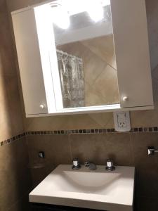 een badkamer met een witte wastafel en een spiegel bij Loft Rosario in Rosario