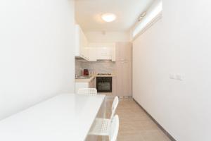 a kitchen with a white counter and white chairs at Casa Leonardo in Casamicciola Terme
