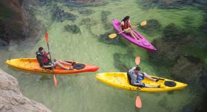 three people are in kayaks in the water at Duplex Ancla in L'Ametlla de Mar