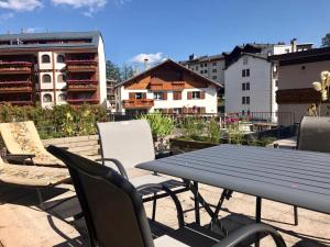 a picnic table and chairs on a patio with buildings at Crans center and close to the ski lifts in Crans-Montana