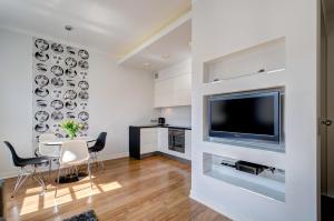 a living room with a television and a table and chairs at Stylish Apartment in Heart of Oldtown in Gdańsk
