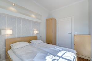 1 dormitorio con 1 cama grande con sábanas blancas en Stylish Apartment in Heart of Oldtown, en Gdansk