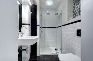a white bathroom with a sink and a shower at Stylish Apartment in Heart of Oldtown in Gdańsk +5 photos