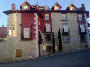 un gran edificio de piedra con ventanas en una calle en La Casa Alta &&&, en Belmonte de Tajo